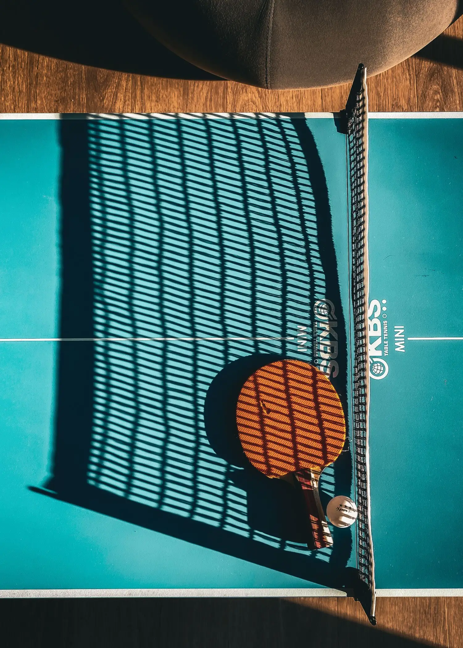 Shadow of a table tennis net falling across an empty table